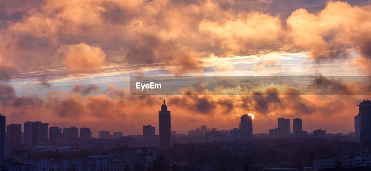 The city smog is illuminated by the rays of the rising sun in the early morning.