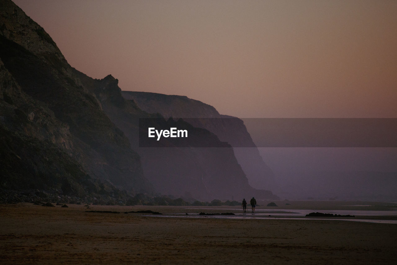 Scenic view of landscape against sky during sunset walk on beach in portugal. 