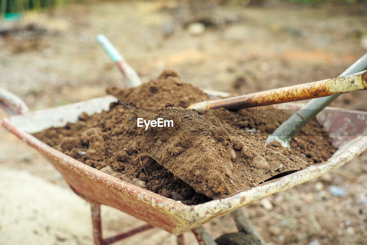Closeup pile of soil on the steel shovels in the wheelbarrow
