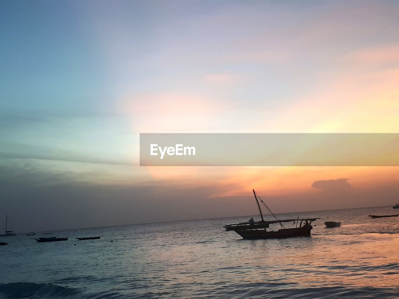 SILHOUETTE SHIP IN SEA AGAINST SUNSET SKY