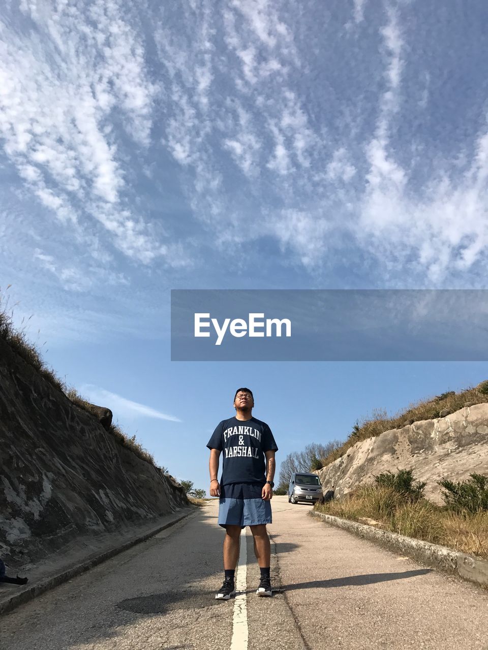 PORTRAIT OF MAN STANDING ON DESERT AGAINST SKY