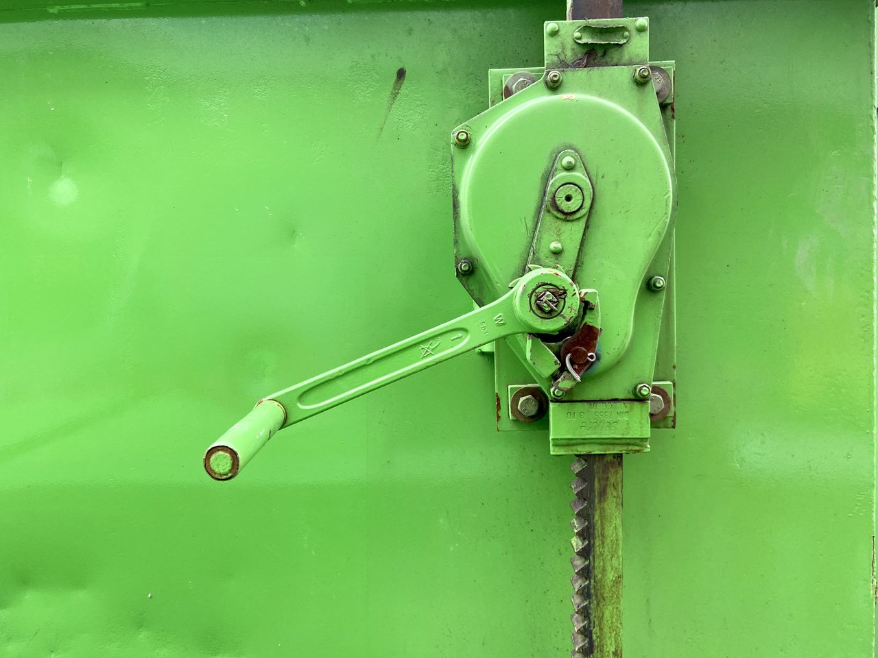 CLOSE-UP OF OLD MACHINE PART WITH GREEN LIGHT
