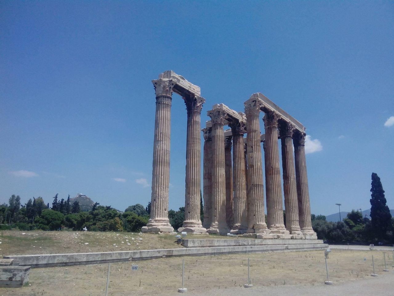 Ancient columns on field against sky