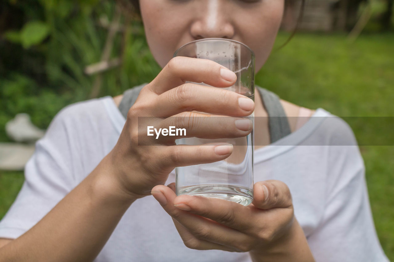 Midsection of woman drinking water