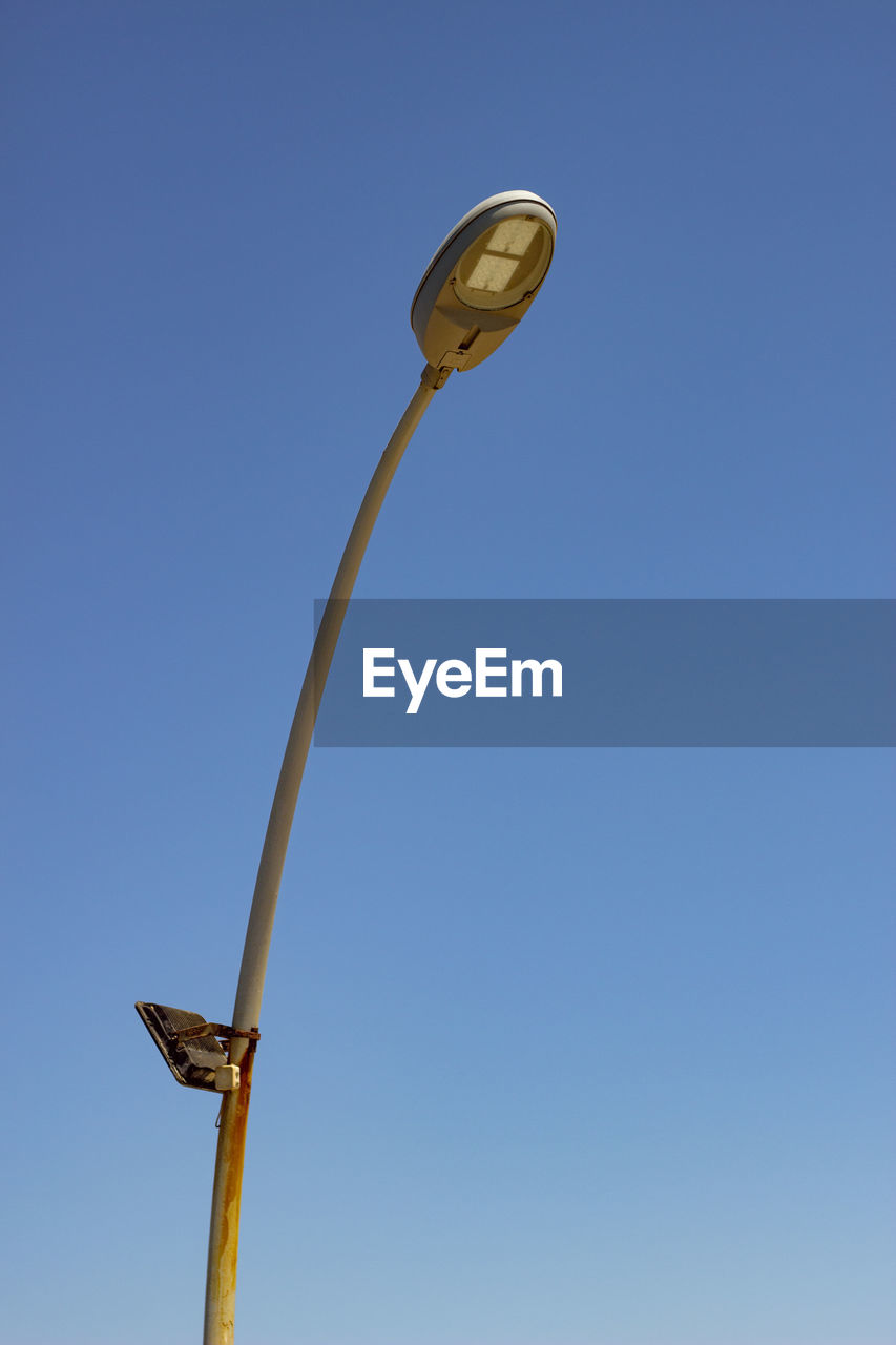 Low angle view of street light against clear blue sky