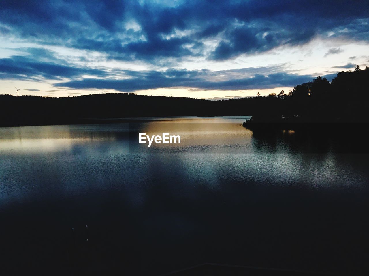 SCENIC VIEW OF LAKE BY SILHOUETTE MOUNTAIN AGAINST SKY