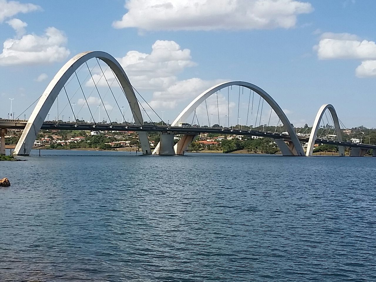 BRIDGE OVER RIVER BY CITYSCAPE AGAINST SKY