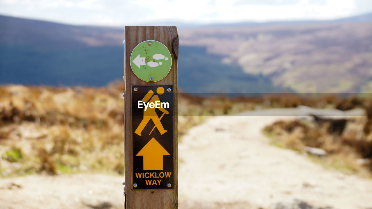 Close-up of road sign against mountains