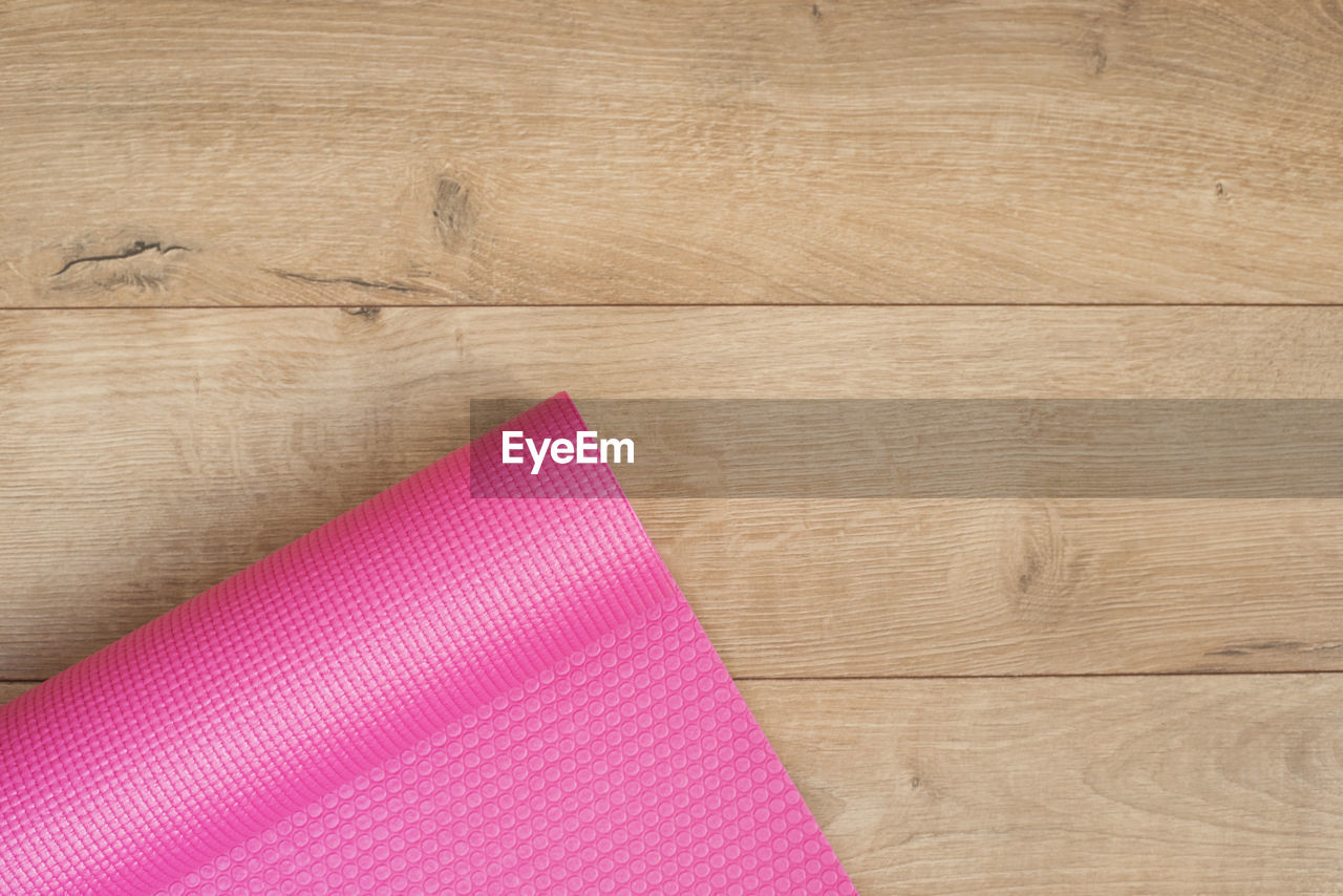 High angle view of pink exercise mat on hardwood floor