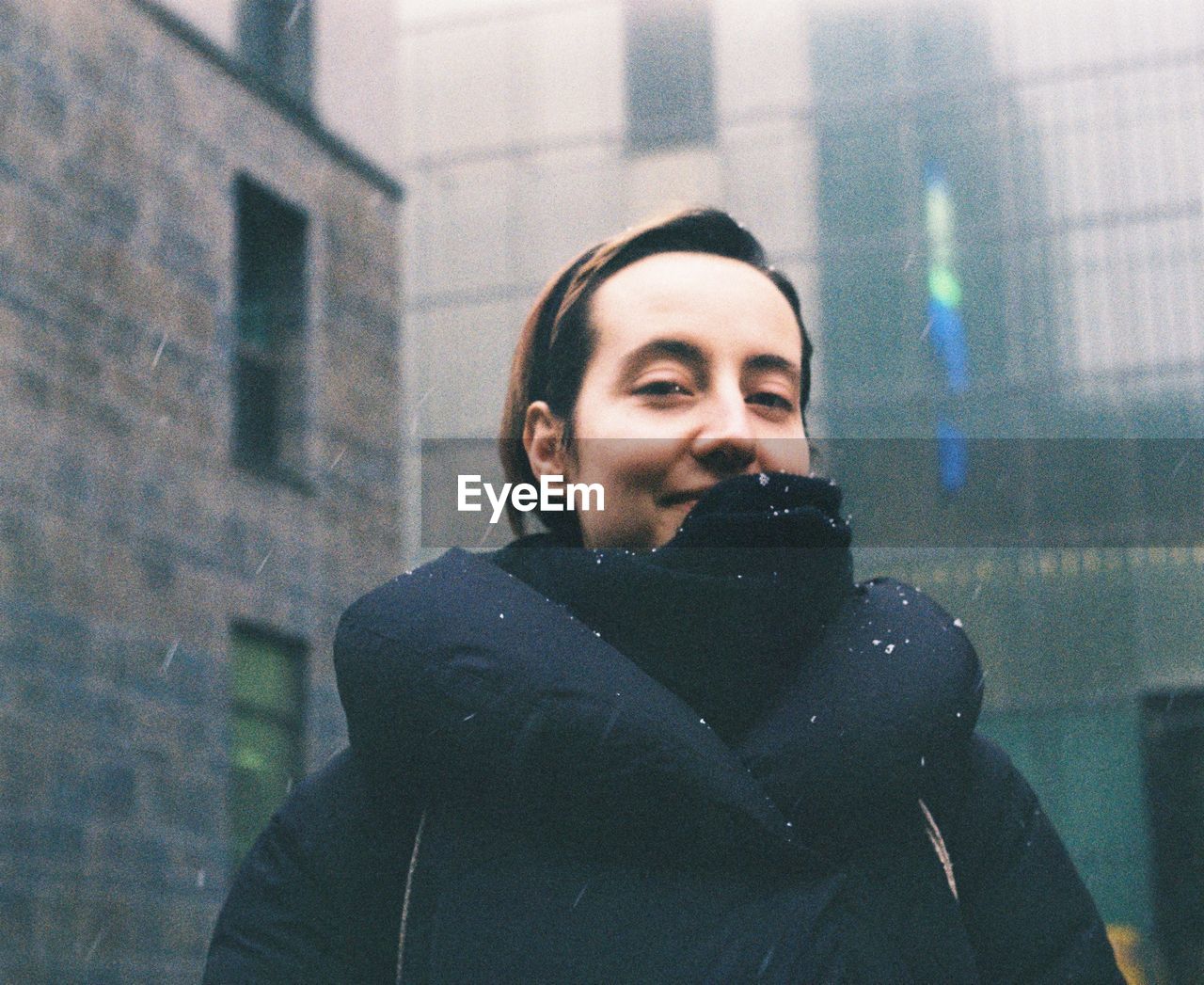 Portrait of woman in jacket during snowfall