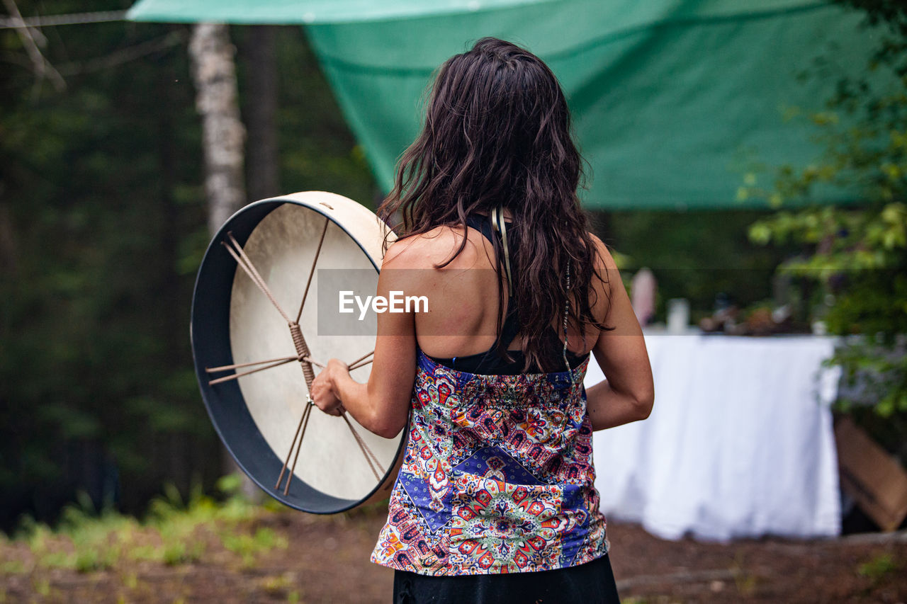 Rear view of woman standing with umbrella