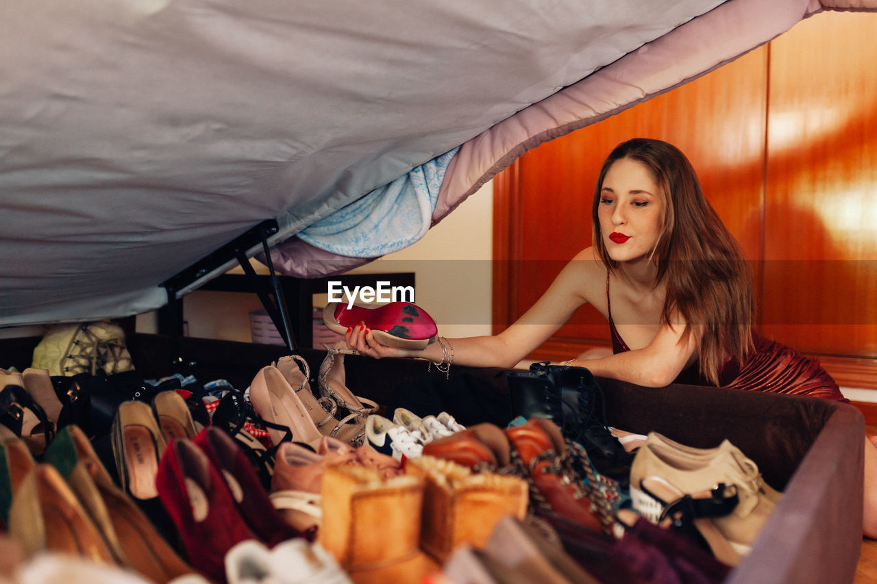 Teenager showing off her large collection of shoes, sneakers and heels.