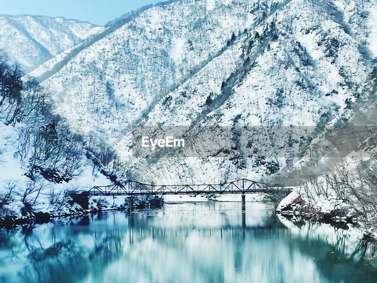 Scenic view of lake by snowcapped mountains during winter in shirakawa-go
