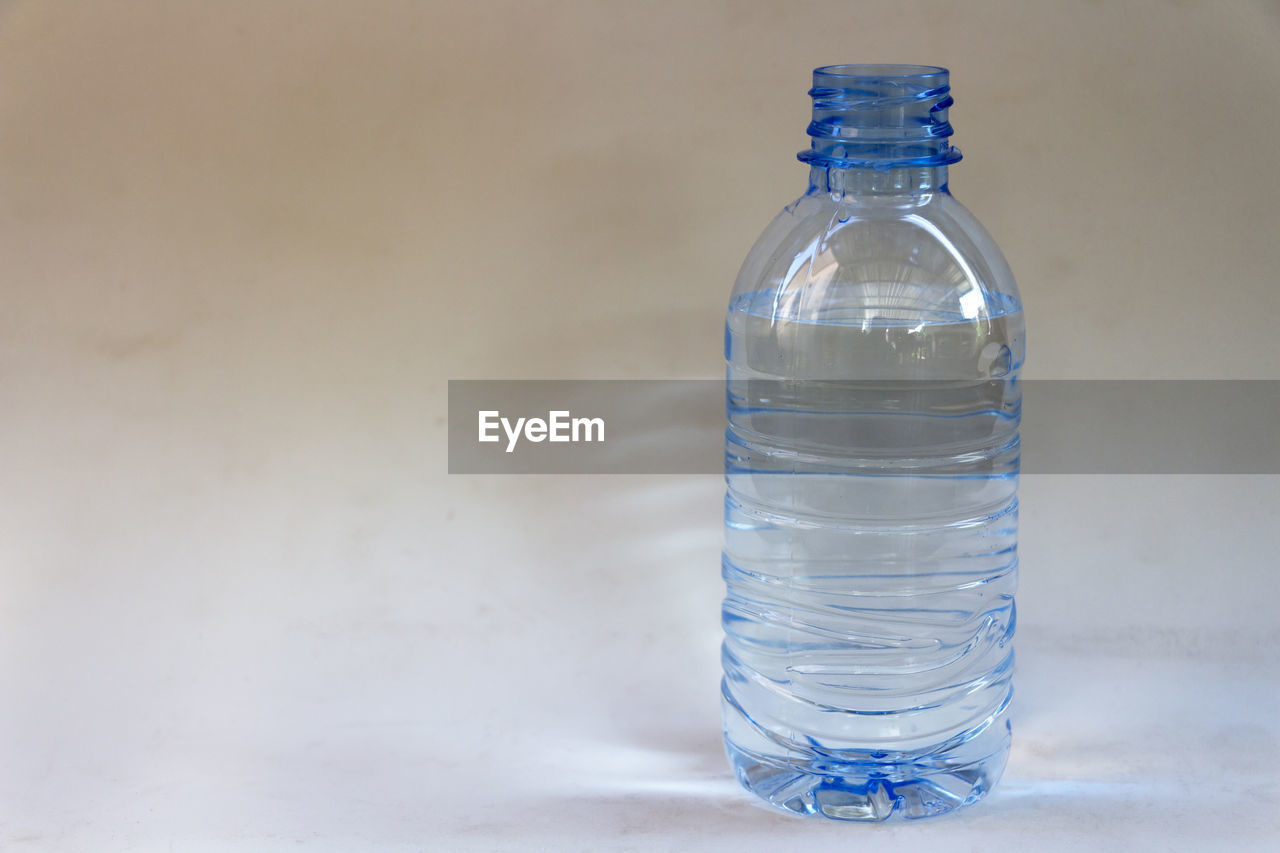 Close-up of water bottle on white table