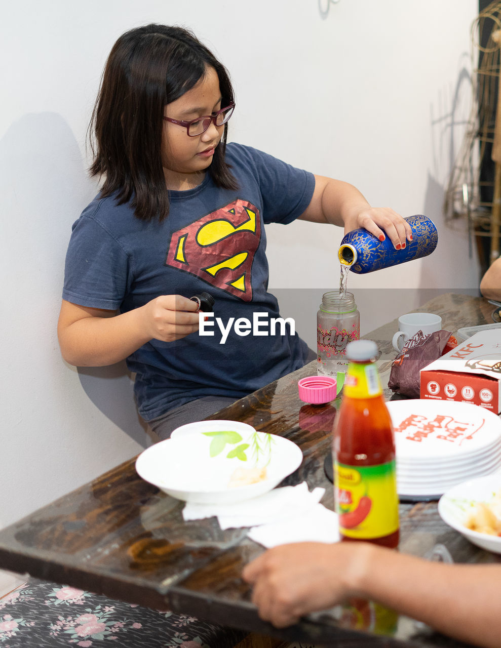 WOMAN LOOKING AWAY WHILE SITTING AT TABLE