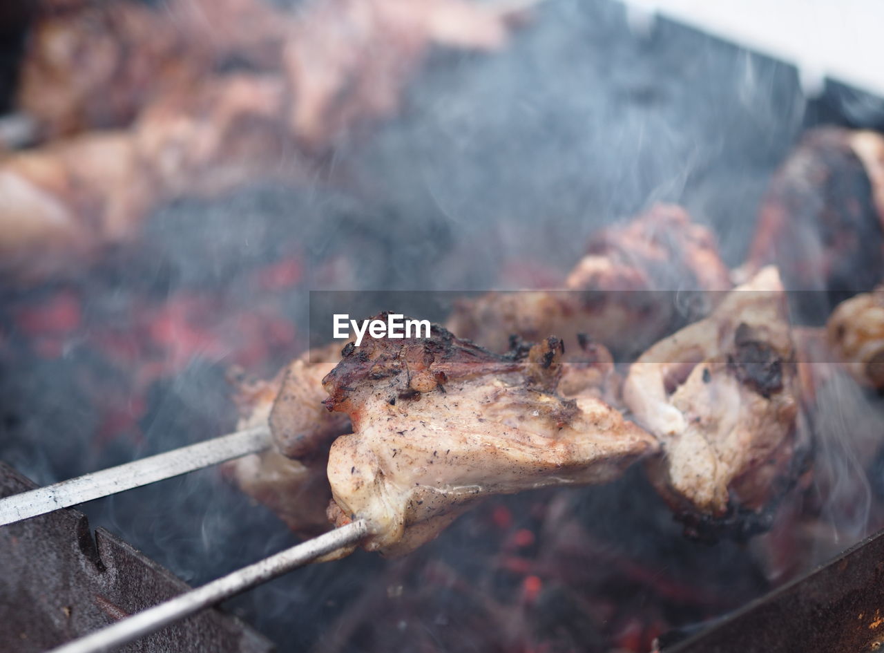 Smoke and steam from skewered fried chicken. winter shish kebab fried over 