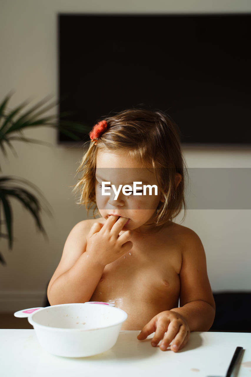 Portrait of cute girl eating food at home