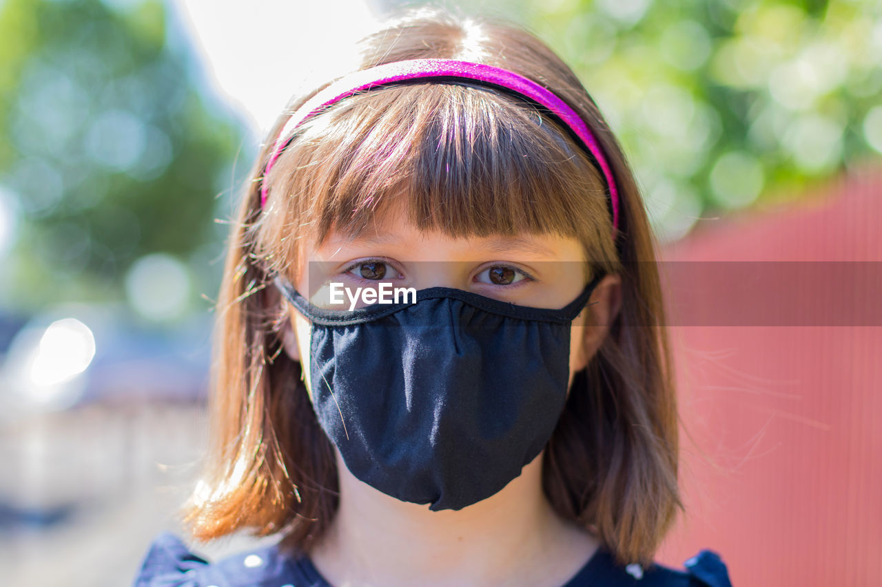 Close-up portrait of girl wearing mask