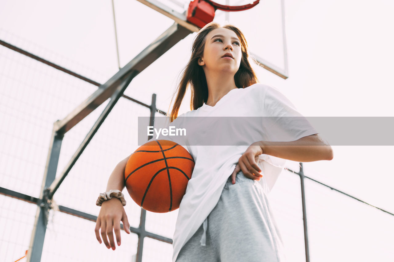 Portrait of young female basketball player. beautiful teen girl playing basketball. 