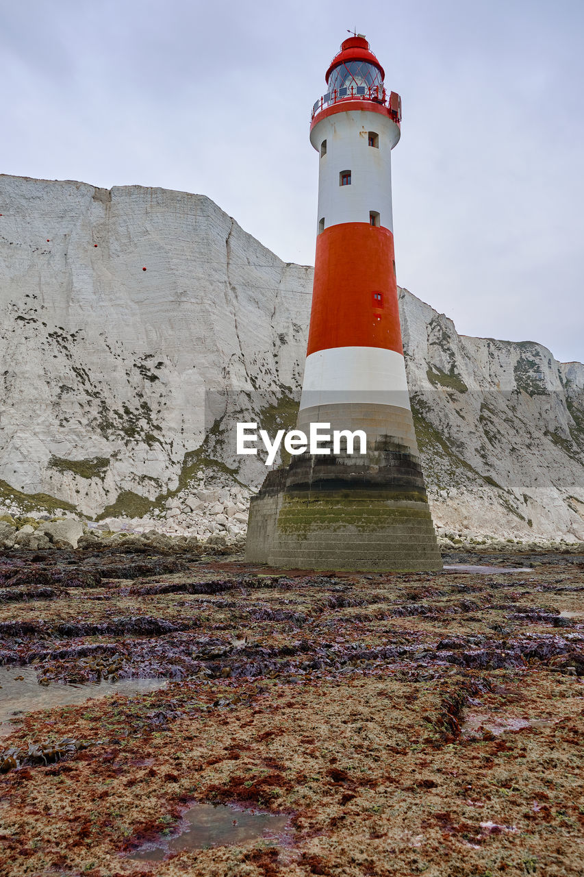 LOW ANGLE VIEW OF LIGHTHOUSE AMIDST BUILDINGS