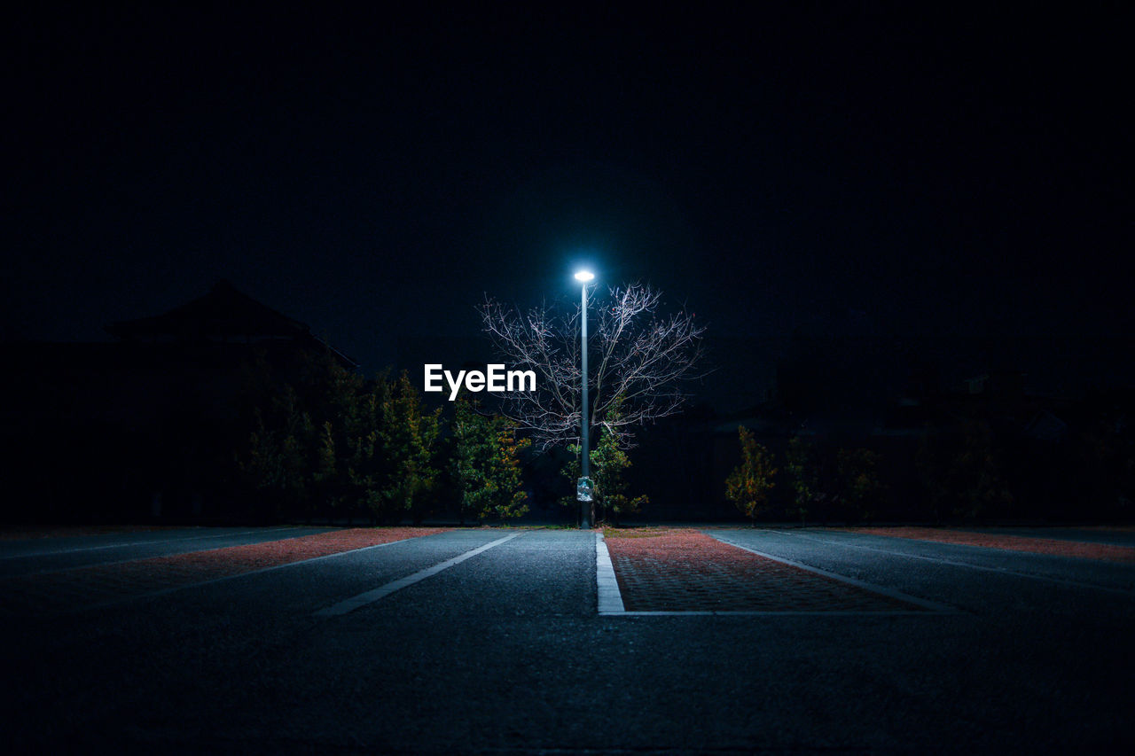 Illuminated street light on footpath at night