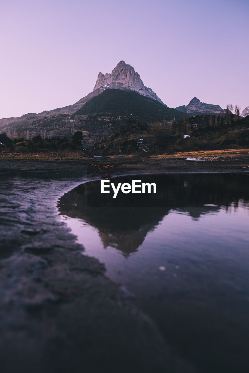 Scenic mountain reflected on a lake during dusk in the pyrenees, spain