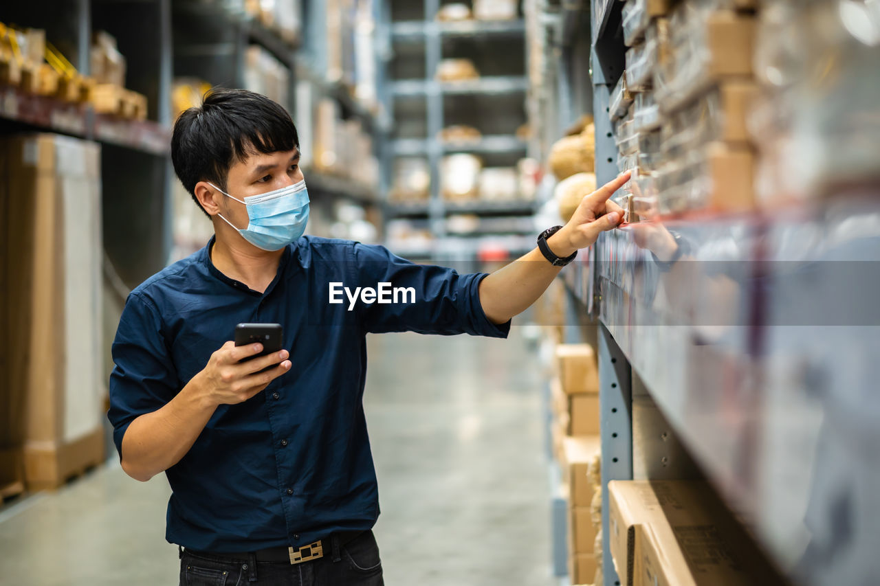 Man wearing mask working in warehouse