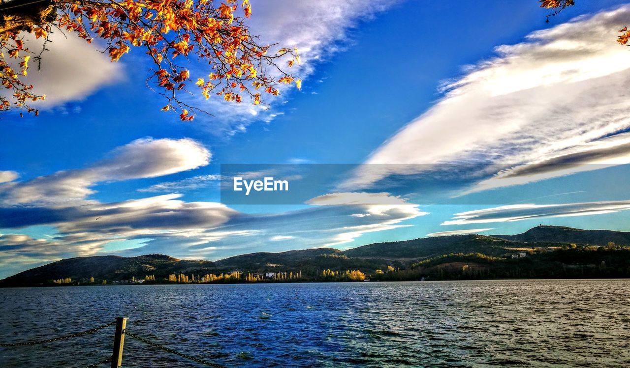 SCENIC VIEW OF LAKE BY MOUNTAINS AGAINST BLUE SKY