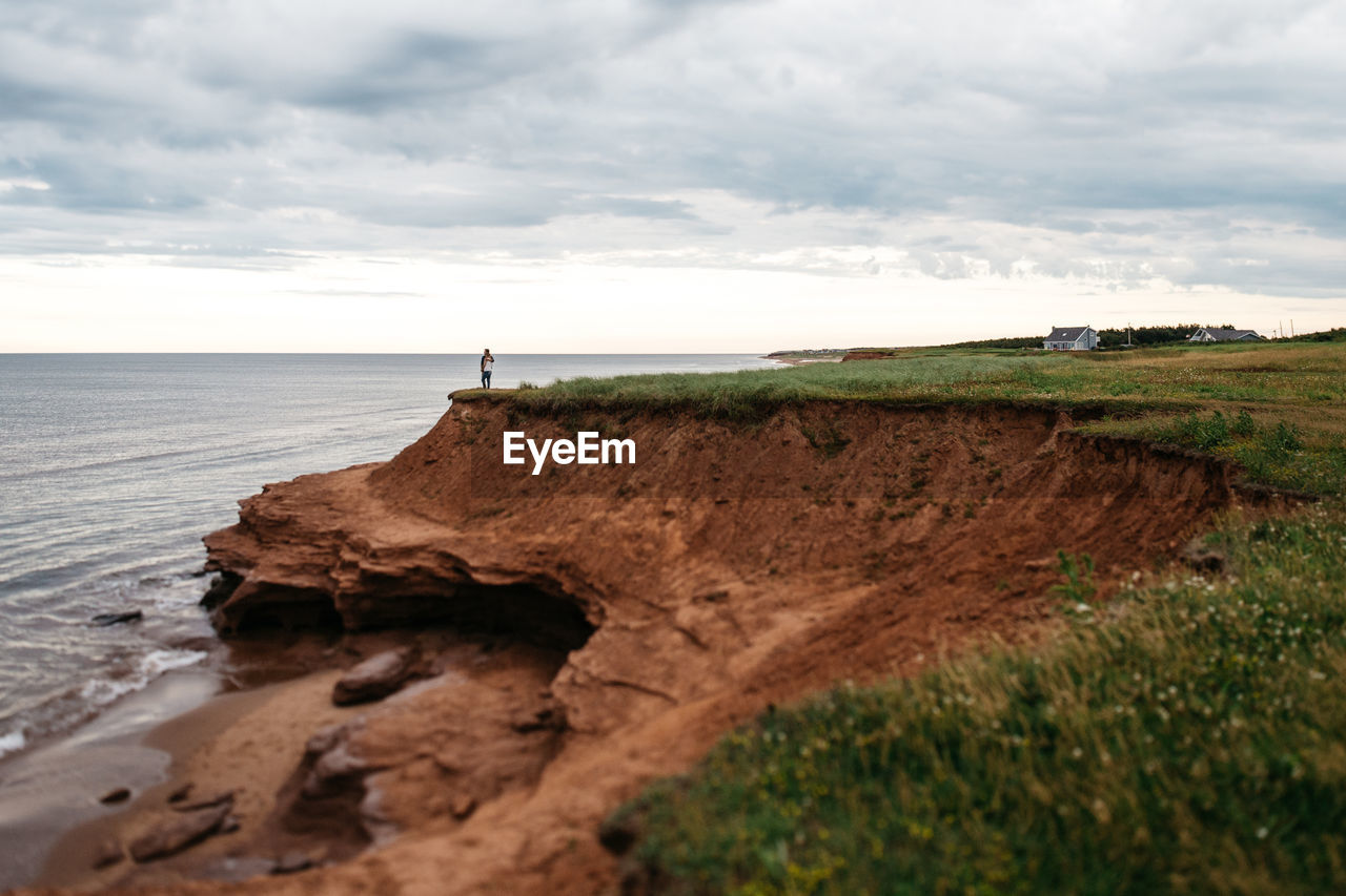 One lonely distant person standing on seashore