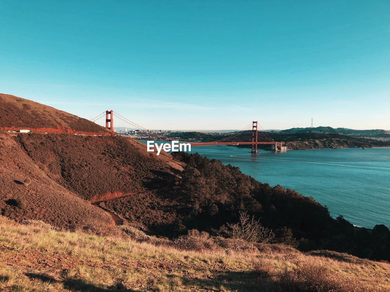 SCENIC VIEW OF SEA AND MOUNTAINS AGAINST CLEAR SKY