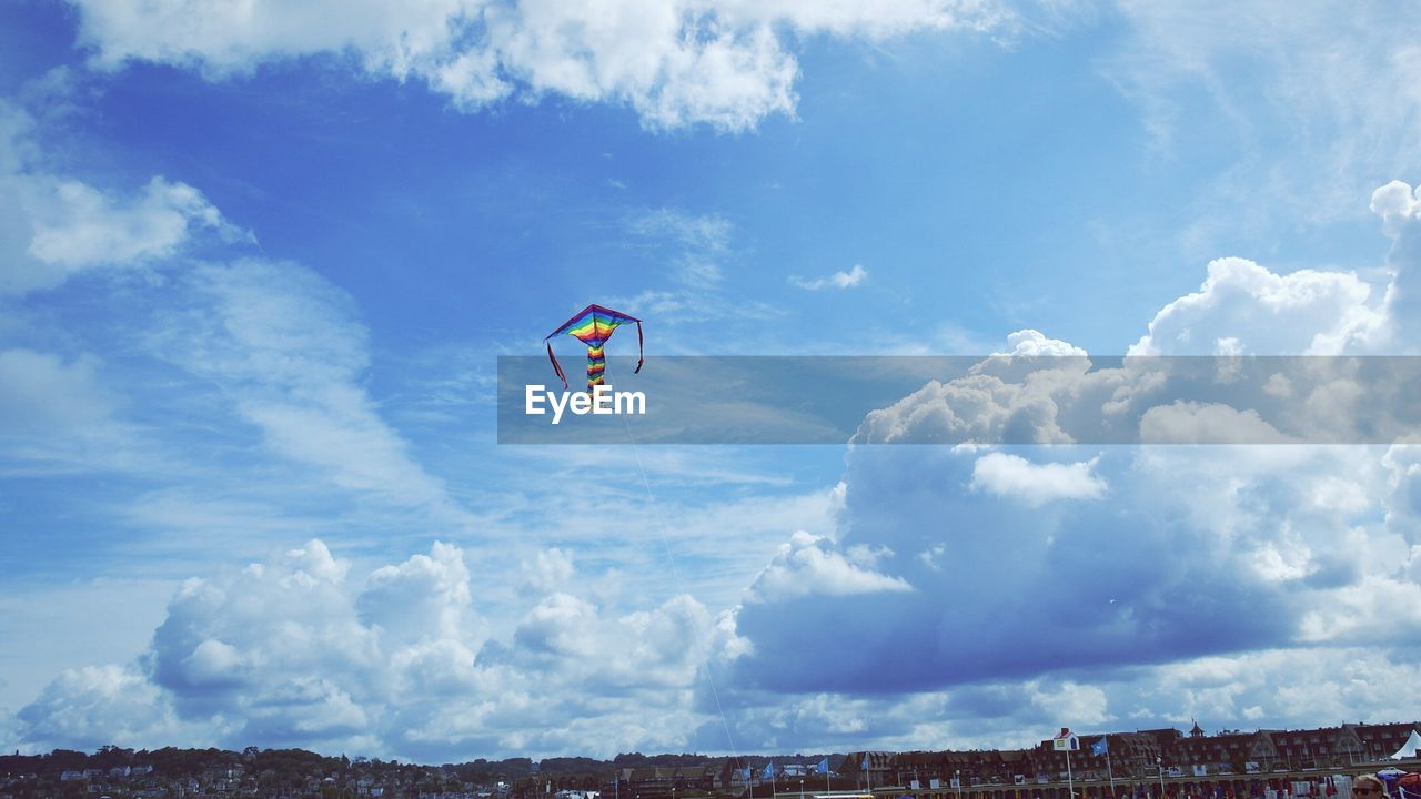 Low angle view of multi colored kite flying on sky