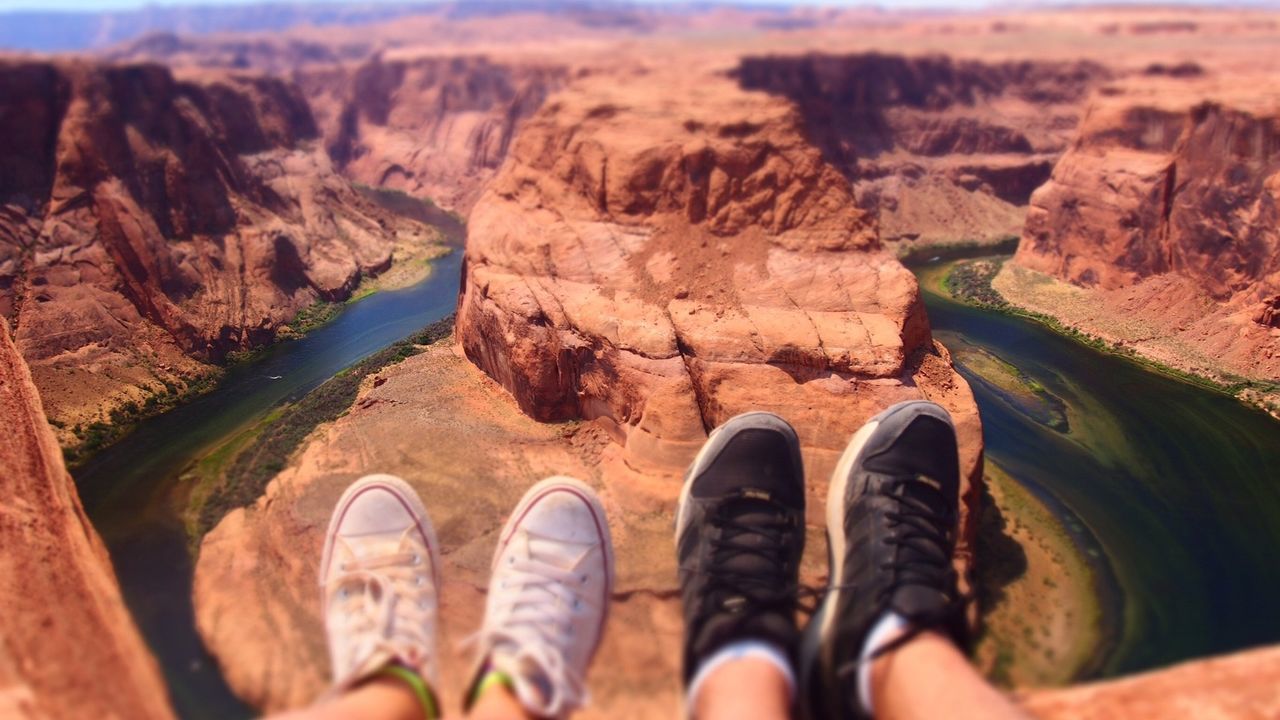 LOW SECTION OF MAN WEARING SHOES ON MOUNTAIN