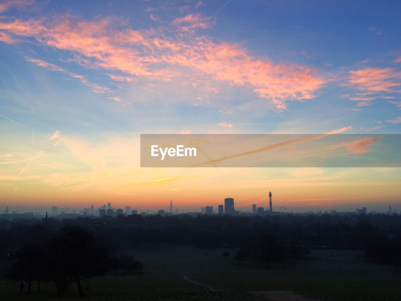 Silhouette city against sky during sunset