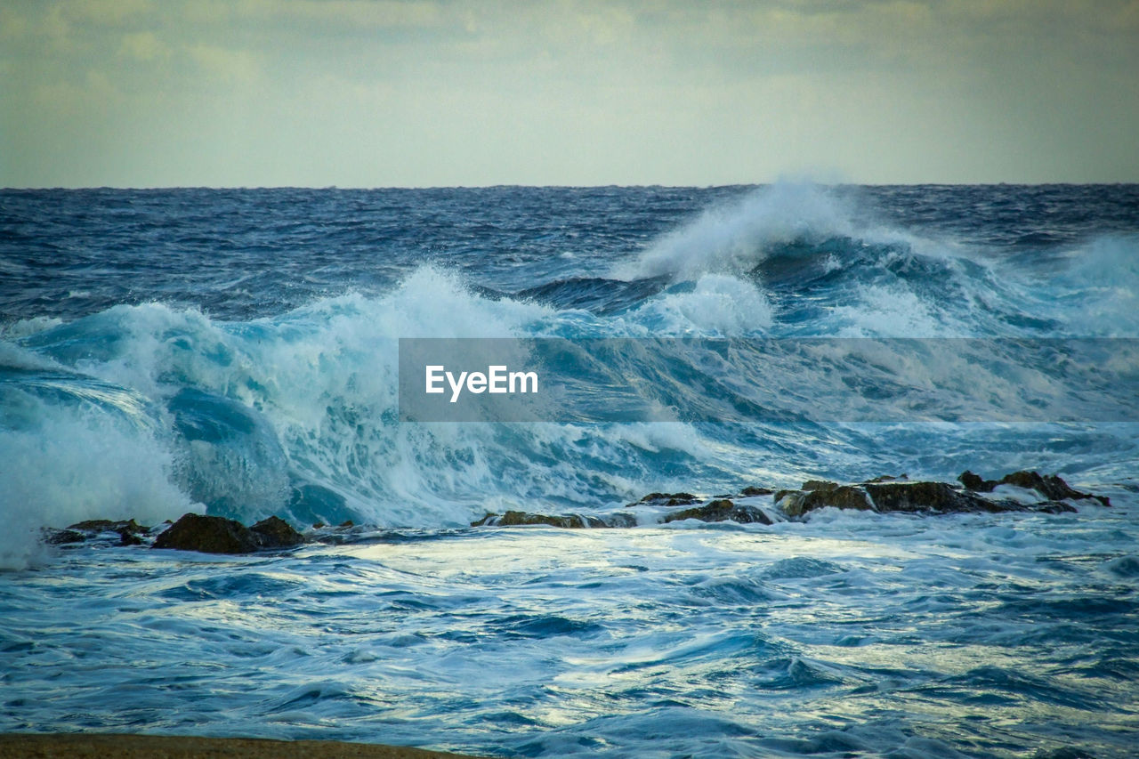 Scenic view of sea with splashing waves