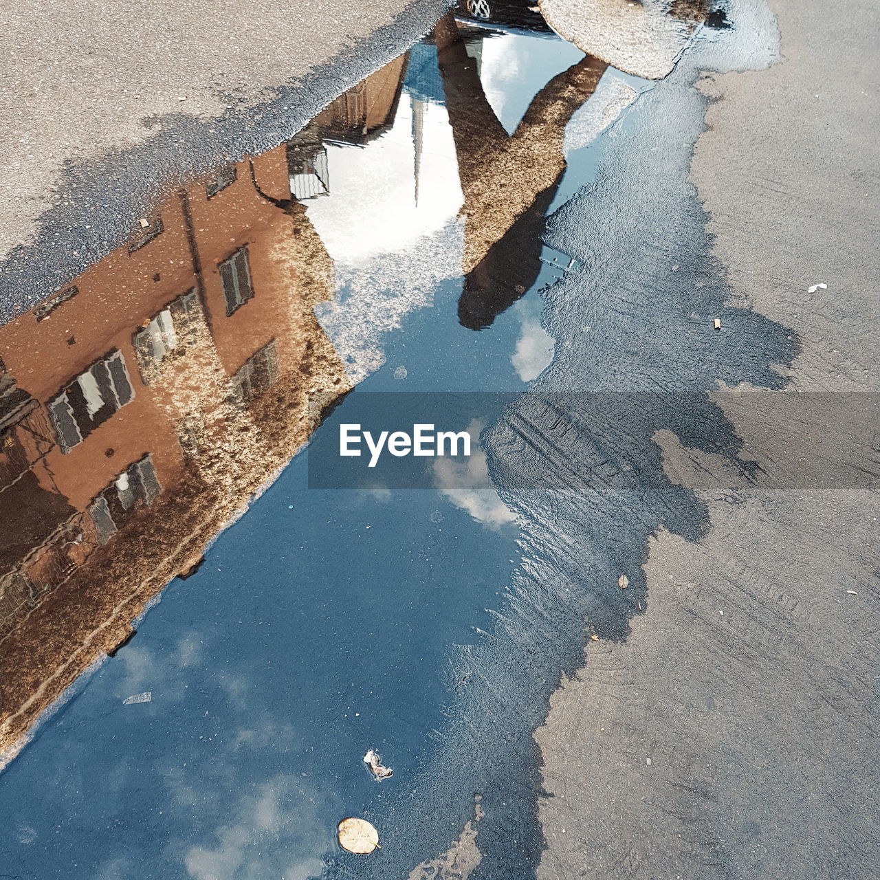 HIGH ANGLE VIEW OF PUDDLE ON WET STREET