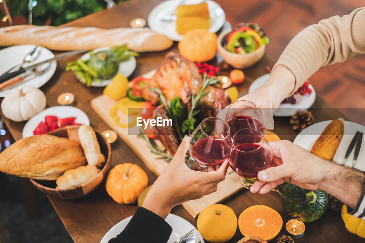 Cropped image of people toasting wineglasses over table