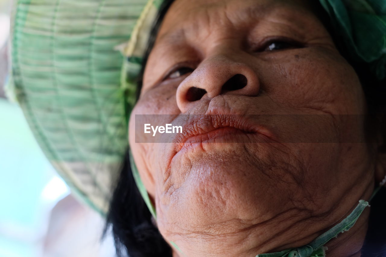 Close-up of senior woman wearing hat outdoors