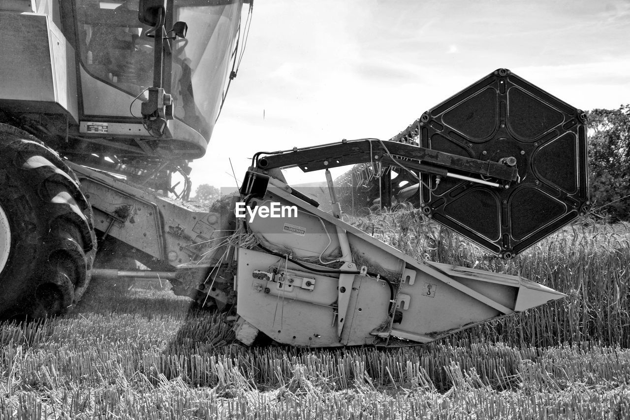Combine harvester on field against sky