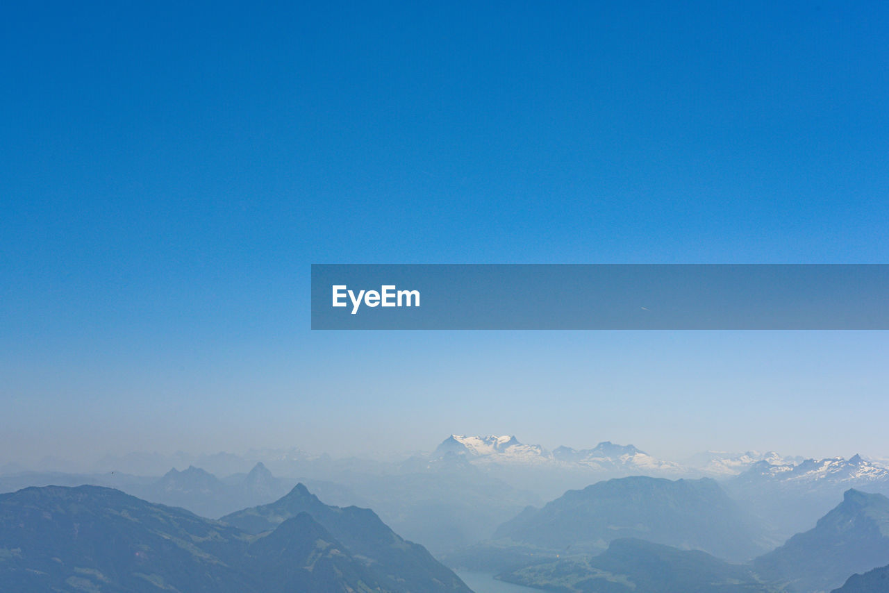 Scenic view of snowcapped mountains against clear blue sky