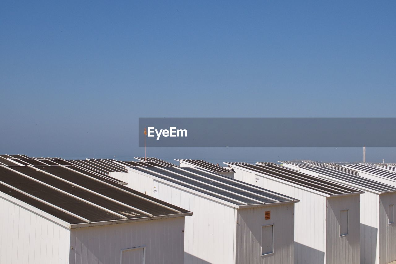 High angle view of beach huts against clear blue sky