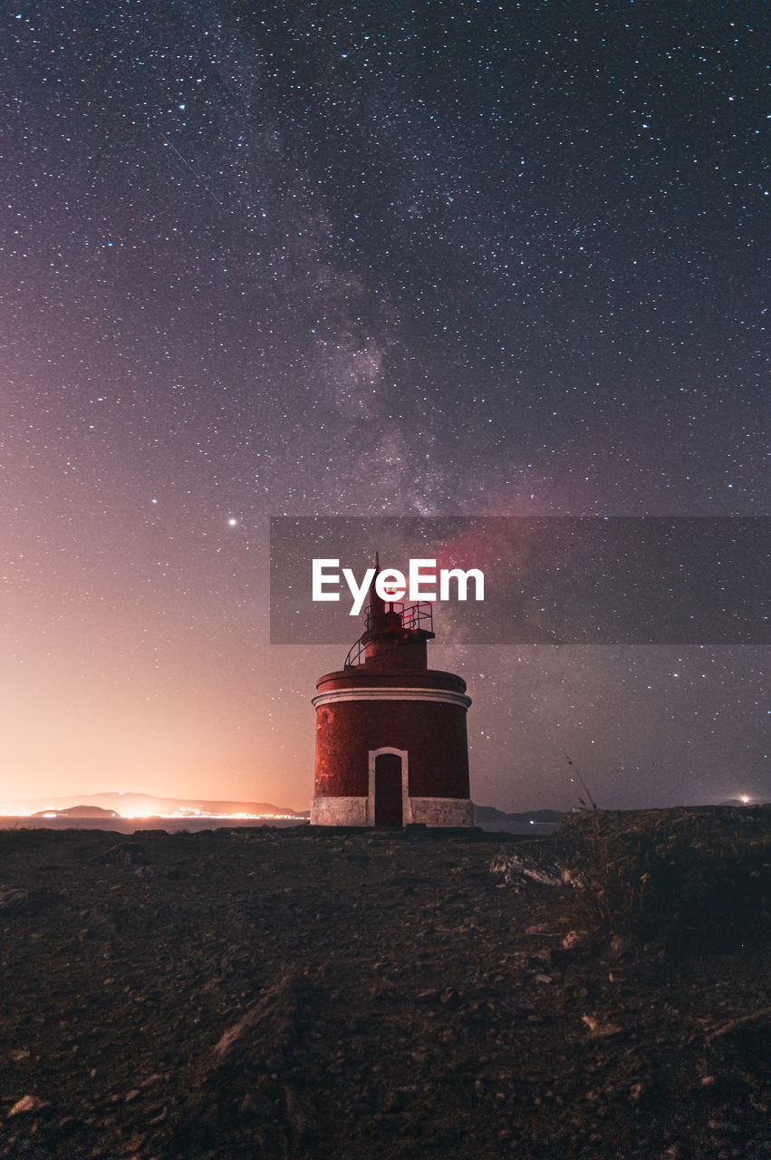 Lighthouse against sky at night