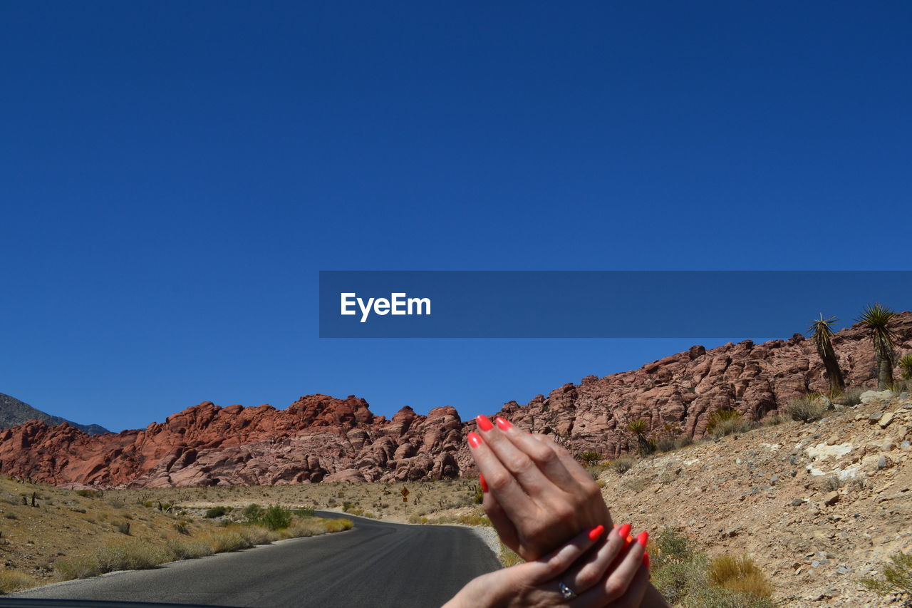 Woman's hands against country road