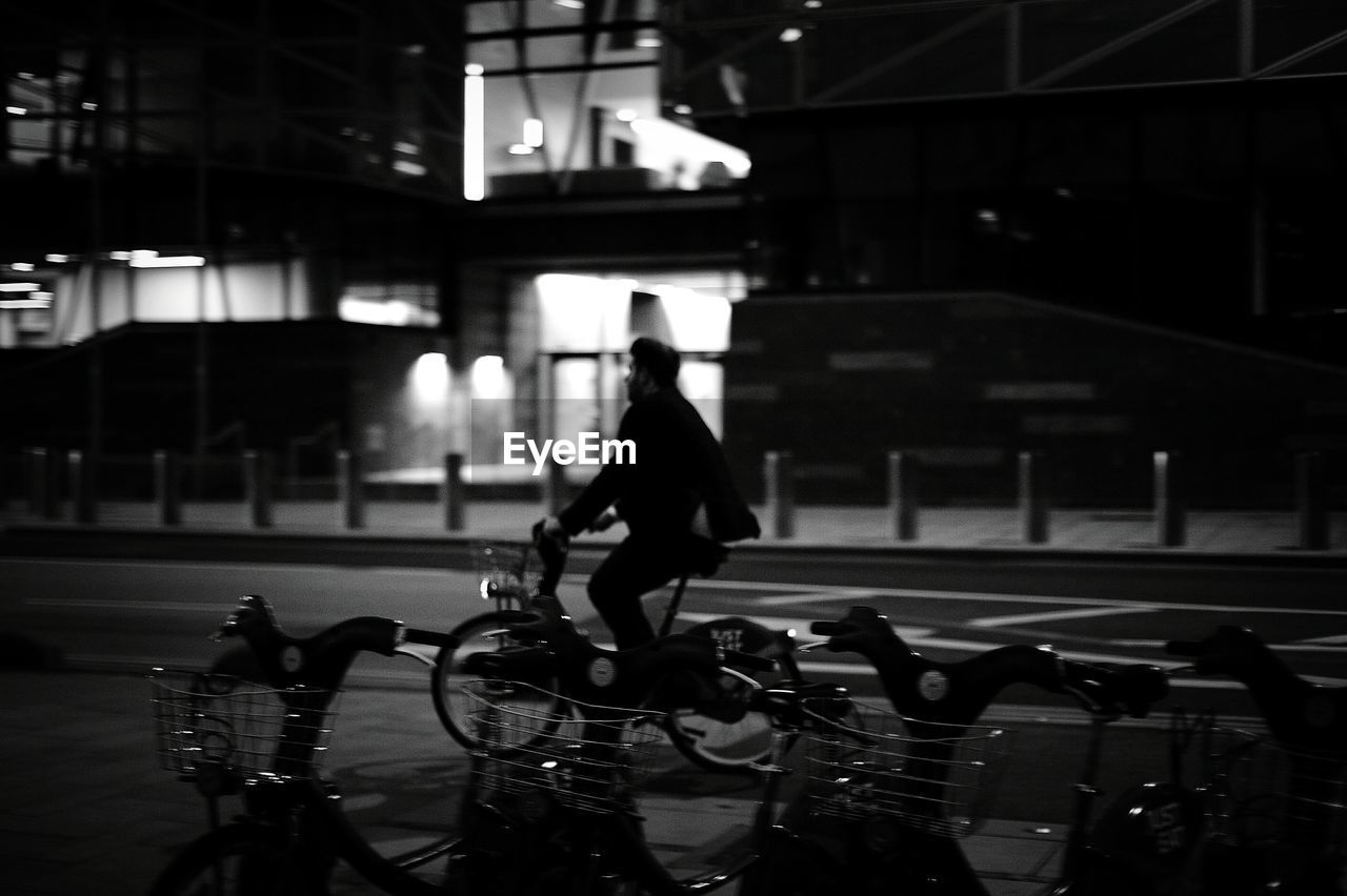 Man riding bicycle on street at night