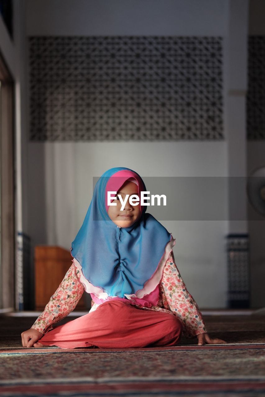 PORTRAIT OF A SERIOUS YOUNG WOMAN SITTING AT TEMPLE