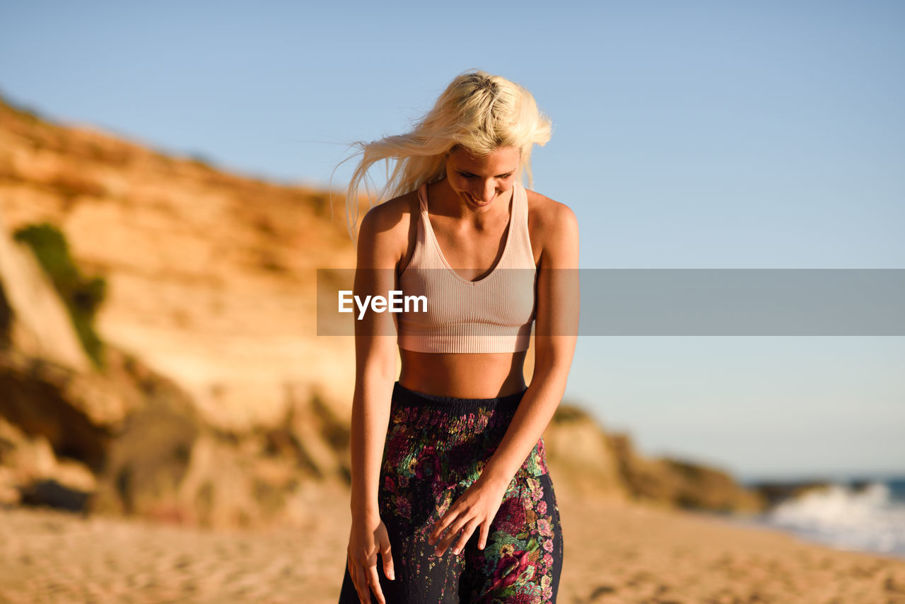 Woman with eyes closed standing on beach