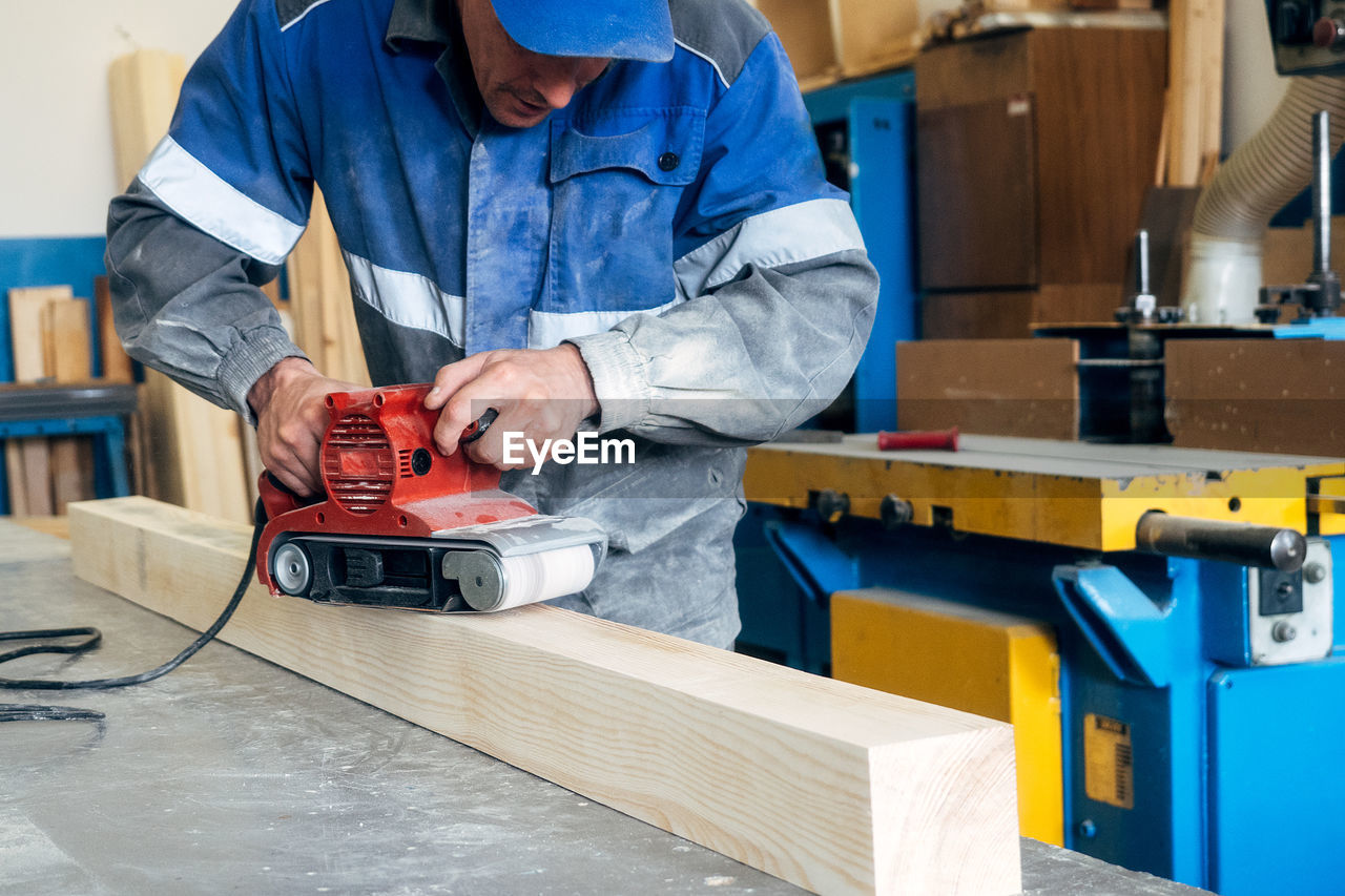 midsection of man working on table