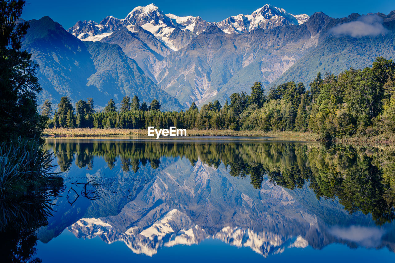 Mountain and trees reflecting on calm lake