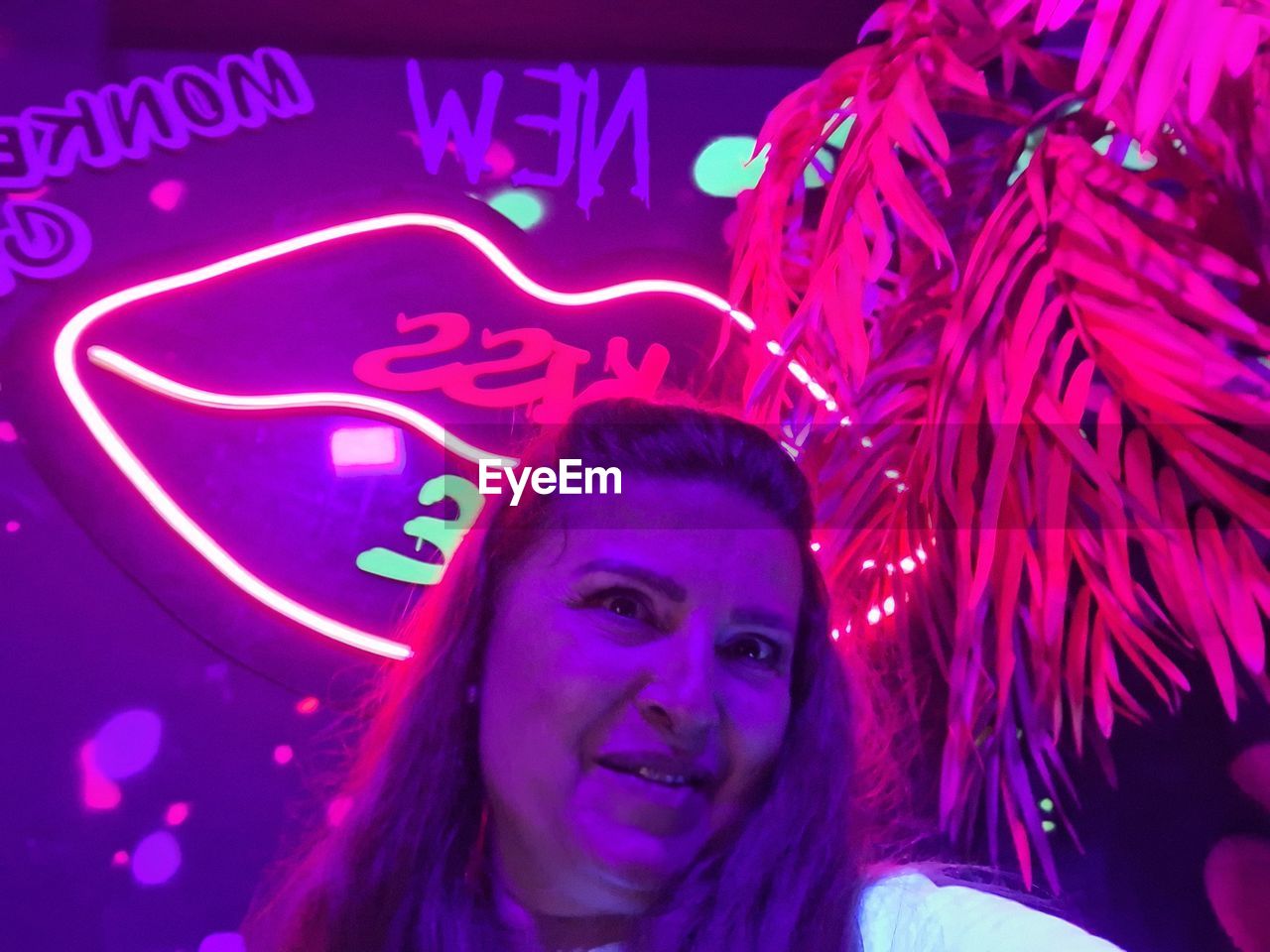 portrait, one person, smiling, headshot, night, adult, women, happiness, disco, looking at camera, illuminated, young adult, emotion, nightclub, event, celebration, enjoyment, indoors, arts culture and entertainment, front view, rave, neon, pink, lifestyles, purple, multi colored