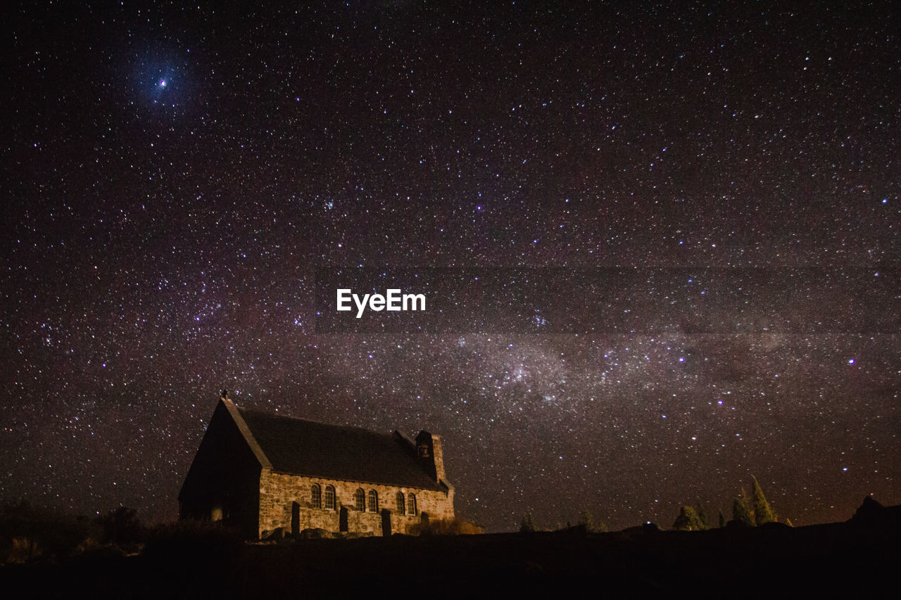 LOW ANGLE VIEW OF BUILDING AGAINST SKY AT NIGHT