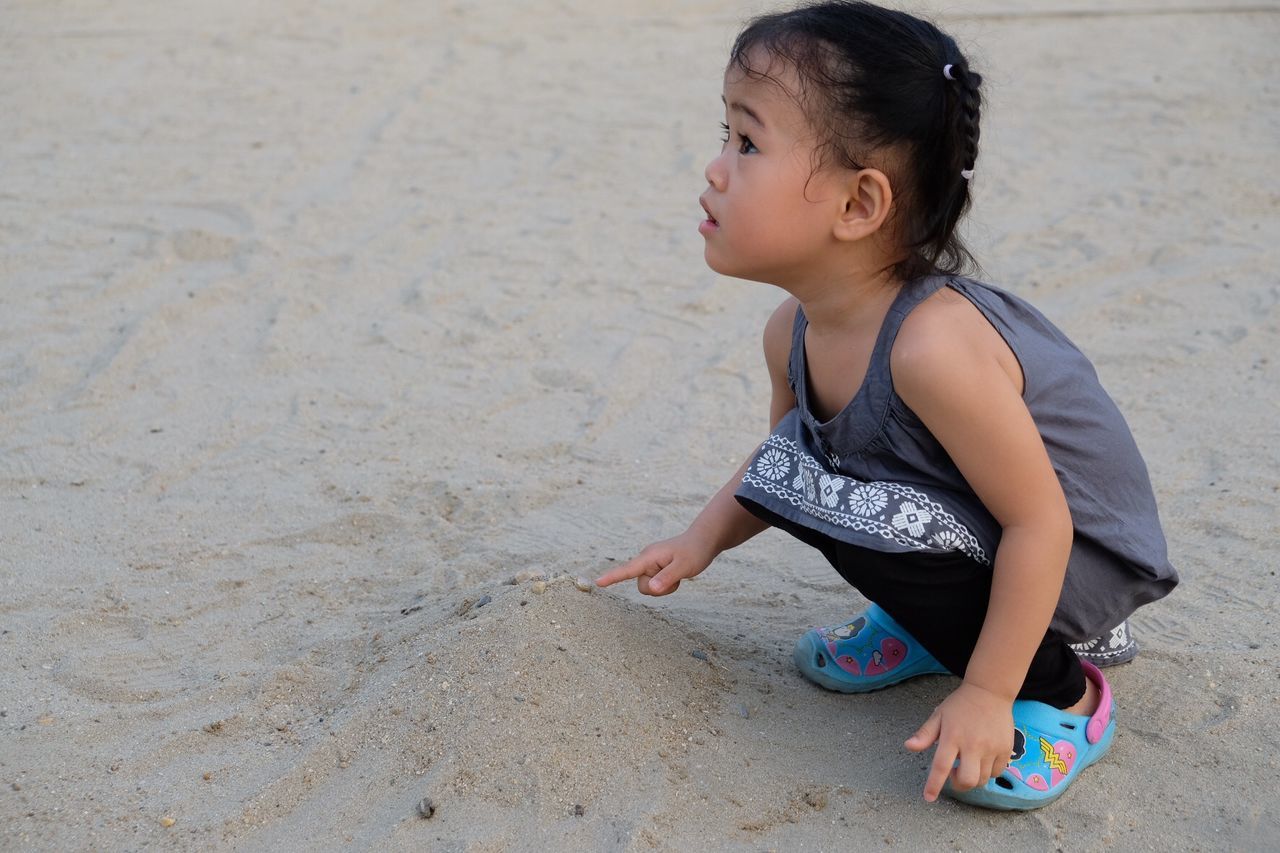 Cute girl crouching at beach